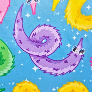 May include: A repeating pattern of cartoon worm illustrations in pink, purple, yellow, and green on a light blue background. The worms have large, expressive eyes and are set against a backdrop of white star shapes.