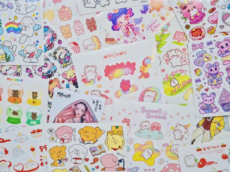 May include: Assortment of colorful stickers featuring cute cartoon characters, animals, and designs. The stickers are on white sheets with various text in Korean and English, including "Waterball", "Sweet Dream", and "Peach Cherry".