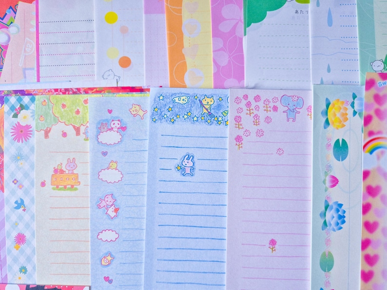 Puede incluir: Una colecci&oacute;n de hojas de papeler&iacute;a coloridas con varios dise&ntilde;os. Algunas hojas presentan papel rayado con ilustraciones de animales, nubes y estrellas. Otras hojas tienen patrones florales, lunares y bordes decorativos.