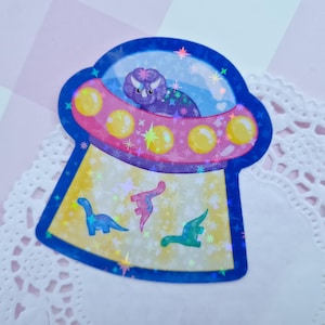 Adesivo Dino Alien Abduction | Cancelleria kawaii con dinosauri, adesivi olografici per bullet journal, cancelleria con Brontosauro Triceratopo, UFO nello spazio