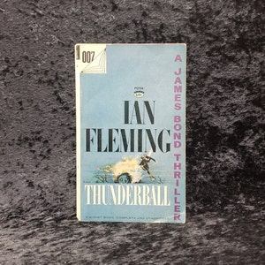 May include: A blue paperback book with the title "Thunderball" by Ian Fleming. The book cover features a man in a wetsuit diving into the water. The book is a James Bond thriller.