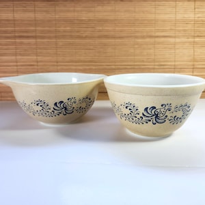Puede incluir: Dos cuencos para mezclar beige con un acabado moteado y un diseño floral azul. Un cuenco tiene un pico. Los cuencos tienen un interior blanco y son aptos para uso en la cocina.