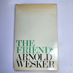 Può includere: Un libro con copertina rigida intitolato "THE FRIENDS" di Arnold Wesker. La copertina è bianco sporco con il titolo in grandi lettere verdi e nere. Il libro mostra segni di usura.