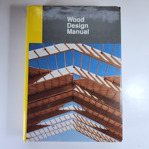 May include: A hardcover book titled "Wood Design Manual" with a yellow spine and a photograph of a wooden structure against a blue sky. The book's cover features a detailed image of a wooden roof.