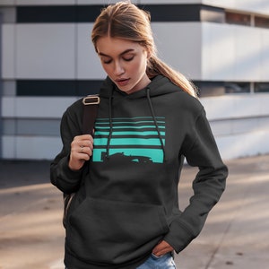 May include: A black hoodie with a turquoise and black graphic of a race car on a striped background. The hoodie has a drawstring hood and a kangaroo pocket.