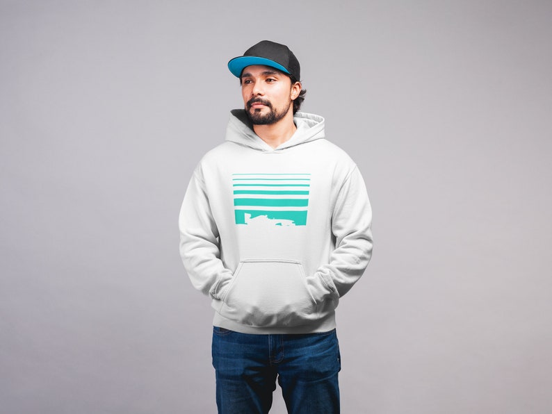 May include: A white hooded sweatshirt with a teal and white graphic design. The graphic features a series of horizontal lines and a stylized image of a car.