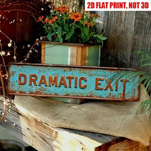 May include: A rectangular metal sign with a distressed turquoise finish and raised copper-colored letters spelling DRAMATIC EXIT. The sign features rust-like edges and is positioned in front of a wooden planter. Text reads 2D FLAT PRINT, NOT 3D.