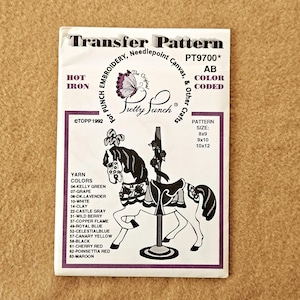 May include: A vintage embroidery transfer pattern featuring a carousel horse design. The pattern includes color codes and sizes 8x9, 9x10, and 10x12 inches. The brand is Pretty Punch, with the text "Hot Iron" and "Transfer Pattern".
