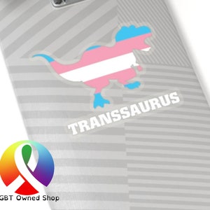 Könnte beinhalten: Ein transparenter Aufkleber mit einer Dinosauriersilhouette in den Farben der Transgender-Pride-Flagge und dem Text "TRANSsaurus".