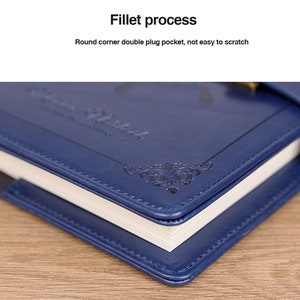 May include: Close-up of a blue leather-bound journal with a decorative design and the text "Vintage Notebook" embossed on the cover. The journal has a rounded corner and a double plug pocket.
