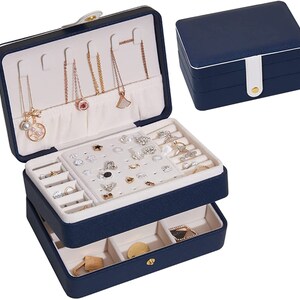 May include: A two-tiered blue jewellery box with a white interior. The top tier has slots for necklaces and earrings, while the bottom tier has compartments for rings and other small items.