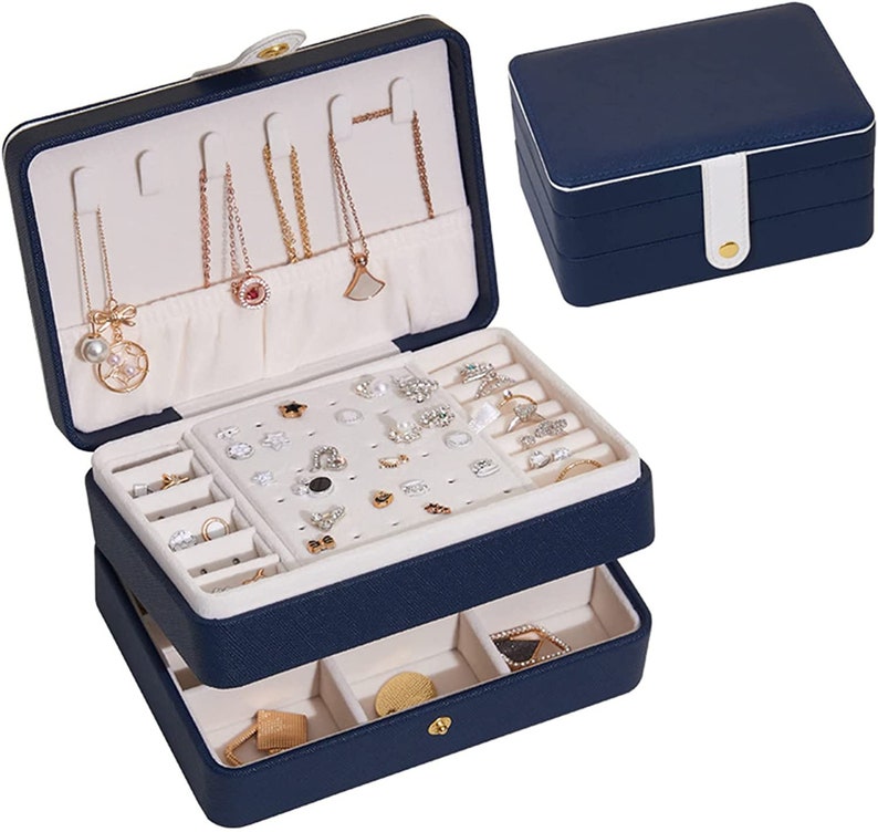 May include: A two-tiered blue jewellery box with a white interior. The top tier has slots for necklaces and earrings, while the bottom tier has compartments for rings and other small items.