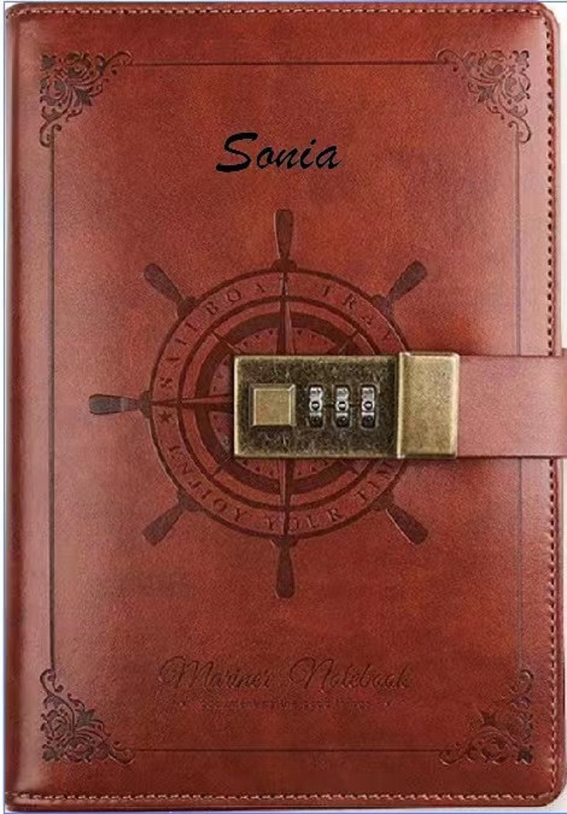 May include: A brown leather journal with a compass design and a combination lock. The journal has the words "Enjoy Your Time" and "Mariner Notebook" printed on it. The name "Sonia" is written on the front cover.