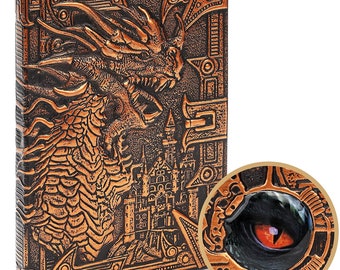 May include: A brown leather-bound journal with an embossed design of a dragon and a castle. The dragon's eye is a red gem.