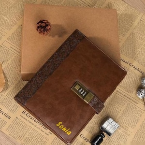 Może przedstawiać: Brązowy skórzany dziennik z złotą kłódką i ozdobnym tłoczonym wzorem. Dziennik ma spersonalizowane imię "Sonia" w złotych literach.