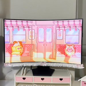 Puede incluir: Un monitor de computadora curvo que muestra el interior de un tren de dibujos animados rosa con dos personajes hámster, con un borde de encaje blanco y pequeños lazos rosas en la parte inferior. Se apoya en un estante de escritorio con tres cajones.