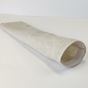 Op de afbeelding: Een beige linnen bestekhouder met een witte naad rond de opening.