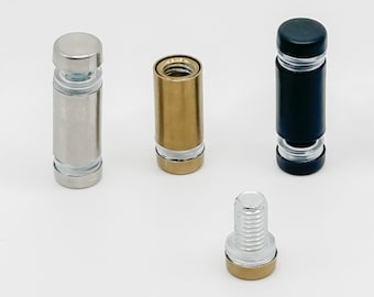 May include: Four different types of metal standoffs, including silver, gold, black, and a screw with a gold base. The standoffs are used to mount signs or other objects to a surface.