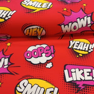 Könnte beinhalten: Roter Stoff mit einem sich wiederholenden Muster aus bunten Sprechblasen mit Wörtern wie "YEAH!" "SMILE!" "WOW!" "HEY" "OOPS!" und "LIKE!"