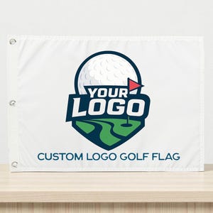 May include: White custom logo golf flag with grommets. The flag features a golf ball and course graphic with the text "YOUR LOGO" and "CUSTOM LOGO GOLF FLAG" in blue.