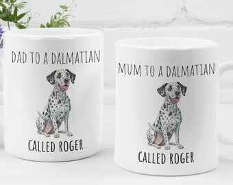 May include: Two white ceramic mugs with black text and a cartoon Dalmatian dog. The mug on the left says "Dad to a Dalmatian called Roger". The mug on the right says "Mum to a Dalmatian called Roger".