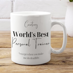 May include: White ceramic mug with black text that reads "Courtney World's Best Personal Trainer *except when you make me do deadlifts"