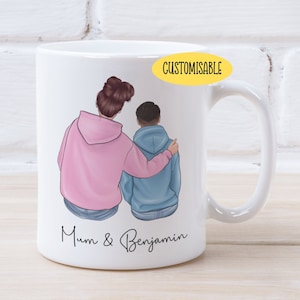 May include: White ceramic mug featuring a colourful illustration of a mother and son hugging from behind. The text "Mum & Benjamin" is printed on the bottom of the mug. The words "CUSTOMISABLE" are printed in yellow on a white oval sticker.