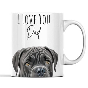 May include: White ceramic coffee mug featuring a black and white illustration of a Cane Corso dog's face peering over the rim. The text "I love you Dad" is printed in black above the dog.