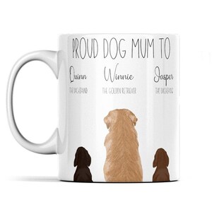 以下が含まれることがあります： 「Proud Dog Mum To」という文字と、「Quinn the Dachshund」、「Winnie the Golden Retriever」、「Jasper the Dachshund」という名前が書かれた白いセラミック製のマグカップ。テキストの後ろに3つの犬のシルエットが表示されています。