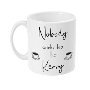 May include: White ceramic mug with black text that reads "Nobody drinks tea like Kerry" with two small drawings of teacups on either side of the text.