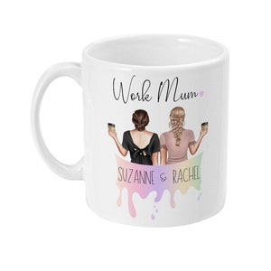 May include: White ceramic mug with a black and pink design. The mug features two women holding coffee cups with the text "Work Mum" and "Suzanne & Rachel" on the mug.