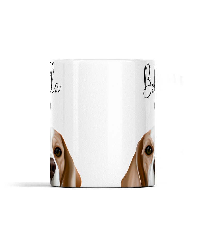 Puede incluir: Taza de cer&aacute;mica blanca con una ilustraci&oacute;n de un perro beagle marr&oacute;n y blanco en ambos lados. El nombre del perro "Bella" est&aacute; escrito en el lado izquierdo de la taza y "Bella" est&aacute; escrito en el lado derecho de la taza.
