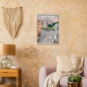 Puede incluir: Un póster de estilo vintage con una ilustración colorida de una escena callejera en Berlín, Alemania. El póster presenta el texto "Prenzlauer Berg Berlin" en la parte superior.