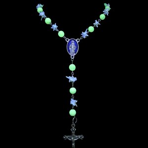 May include: A green and white glow-in-the-dark rosary with a silver cross and a silver pendant featuring a depiction of the Virgin Mary.