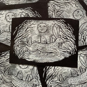 Peut inclure: Illustration en noir et blanc d'un lièvre courant dans une forêt avec une pleine lune en arrière-plan. Le lièvre court devant un groupe de pierres debout.