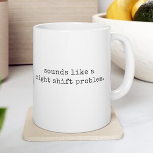 Puede incluir: Taza de café de cerámica blanca con texto negro que dice "sounds like a night shift problem."
