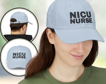 May include: A pale blue baseball cap featuring the text "NICU NURSE" in black. The cap has a curved peak and is made of a soft fabric. The image includes a side and back view of the cap.