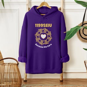 May include: Purple hoodie with a gold graphic of hands forming a circle around a heart with the text "1199SEIU Because We Care".