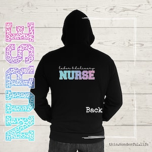 May include: Black hooded sweatshirt with the text "labor & delivery NURSE" printed on the back in a colorful, glittery font.