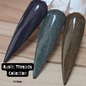 May include: Three nail polish swatches on clear plastic sticks, featuring a deep purple, a dark forest green, and a bronze brown, all with a fine glitter finish. The text "Rustic Threads Collection" and "TLCDips" is printed in white on a black background.