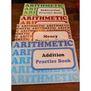 Puede incluir: Una pila de libros de ejercicios de aritmética vintage. Los libros son de varios colores, incluyendo verde, rojo y azul. Los títulos incluyen "Subtraction Practice Book", "Money" y "Addition Practice Book".