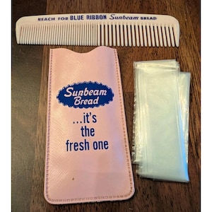 Op de afbeelding: Een vintage Sunbeam Bread promotieset. Inclusief een witte kam met tekst, een roze etui met de tekst "Sunbeam Bread ...it's the fresh one" en verschillende doorzichtige plastic zakken. De items zijn gerangschikt op een houten oppervlak.