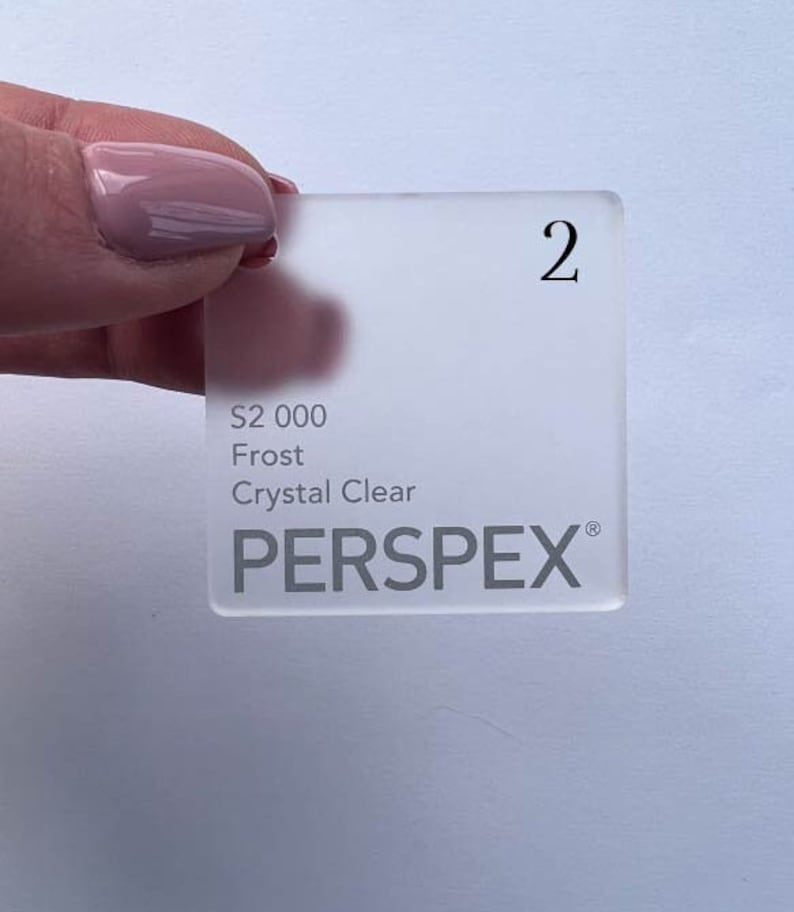 May include: A white frosted acrylic sheet with the text "S2 000 Frost Crystal Clear PERSPLEX" printed on it. The sheet is labeled with the number "2".