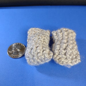 May include: Two gray crocheted boot cuffs with a sparkly texture.