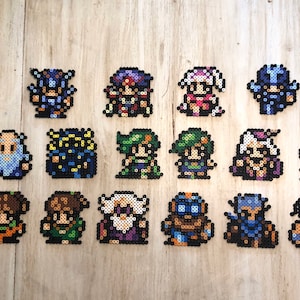 Può includere: Una collezione di 16 personaggi di pixel art realizzati con perline colorate. I personaggi sono disposti in quattro file di quattro. I personaggi includono un cavaliere, un mago, un guerriero, un mago, un ladro, un monaco, un mago bianco, un mago nero, un mago rosso, una ballerina, un bardo, un evocatore, un ninja, un samurai, un drago e una fenice.