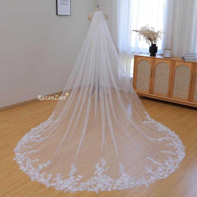 May include: A long white bridal veil with a delicate lace trim. The veil is made of soft tulle and has a cathedral length.