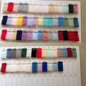 May include: A color chart of 90 fabric swatches, arranged in rows of 15. The swatches are made of a sheer, lightweight fabric, possibly tulle or organza. The colors range from light to dark, and include shades of red, blue, green, yellow, pink, and white.