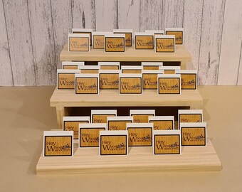 Puede incluir: Un expositor de madera con tres niveles, cada nivel contiene varias tarjetas cuadradas pequeñas con el texto "Hey Woodcraft" impreso en ellas.