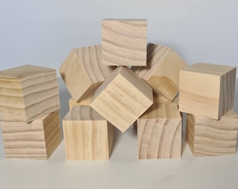 Puede incluir: Un grupo de nueve bloques de madera sin terminar, algunos apilados uno encima del otro. Los bloques son todos del mismo tamaño y forma, y están hechos de madera de color claro.