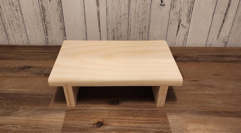 Puede incluir: Un elevador de madera natural simple y rectangular con una parte superior rectangular y dos lados abiertos. El elevador est&aacute; hecho de madera sin terminar y tiene un color marr&oacute;n claro.